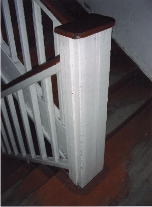 Интерьер лестничной клетки.Фрагмент ограждения и столбик деревянной лестницы